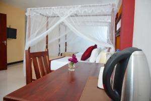 una mesa de madera con un jarrón de flores. en Meili Lanka City Hotel, en Kandy