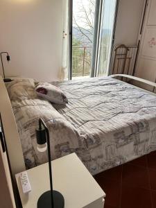 a bed in a room with a table and a window at Maltina country house in Savona