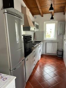 a kitchen with a refrigerator and a tile floor at Maltina country house in Savona +11 photos