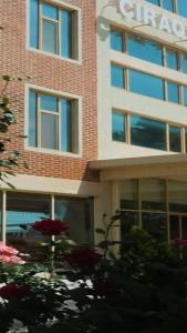 a brick building with windows and flowers in front of it at Cirag Hotel Kurdemir in Kyurdamir