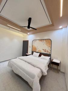 a bedroom with a large bed with a ceiling fan at Hotel Amora in Dighori Buzurg