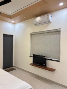 a room with a bed and a window and a air conditioner at Hotel Amora in Dighori Buzurg