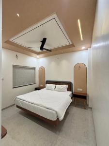 a bedroom with a large bed with a ceiling at Hotel Amora in Dighori Buzurg
