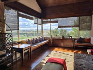 a living room with a couch and large windows at Hotel Rural & Spa Las Nubes in Albalate de Zorita