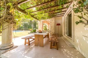 a patio with a table and benches and a pergola at Villa Alegria in Azeitao