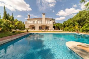 a large swimming pool in front of a house at Villa Alegria in Azeitao