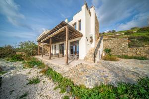 a house on a hill with a stone walkway at Villa Pantheon with Private Pool & Jacuzzi in Pomos