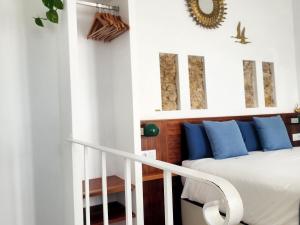 a bedroom with a bed with blue pillows at Riad Vejerísimo - Unique private patio house 8 pers in Vejer de la Frontera