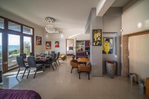a dining room and living room with a table and chairs at Villa Pantheon with Private Pool & Jacuzzi in Pomos