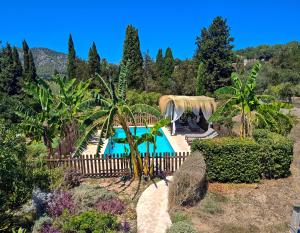 a pool in a garden with a fence and trees at S'abeurada con piscina en Soller in Sóller