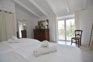 a white bedroom with two white towels on two beds at S'abeurada con piscina en Soller in Sóller