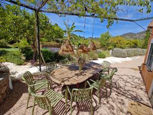 a wooden table and chairs in a yard at S'abeurada con piscina en Soller in Sóller