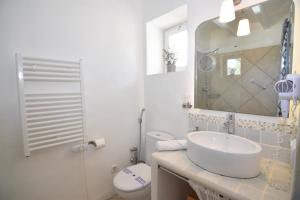 a bathroom with a sink and a toilet and a mirror at S'abeurada con piscina en Soller in Sóller +31 photos