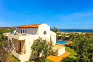 an aerial view of a white house with a swimming pool at Villa Anna Maria by Villa Plus in Pírgos Psilonérou