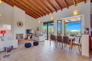 a living room with a table and chairs at Villa Anna Maria by Villa Plus in Pírgos Psilonérou