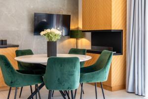 a dining room with a table and green chairs at Mountain Mood by Apart Concept Podhale in Kościelisko