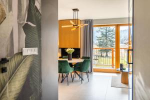a dining room with a table and green chairs at Mountain Mood by Apart Concept Podhale in Kościelisko +28 photos