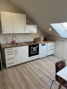 a kitchen with white cabinets and a stove top oven at Appartement 4 morangis in Morangis +8 photos