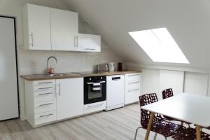 a kitchen with white cabinets and a table with chairs at Appartement 4 morangis in Morangis