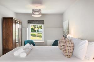 a bedroom with a white bed with two stuffed animals on it at 4 Bed in St. Brides oc-o30488 in Saint Brides