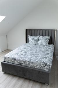 a bed in a bedroom with a white wall at Appartement 4 morangis in Morangis