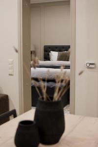 a room with a bed and a vase on a table at Boutique Vaksali Apartment in Viljandi