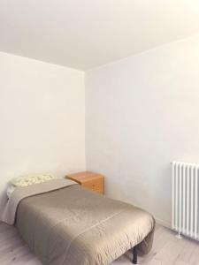 a small bedroom with a bed and a night stand at Levico Antiche Terme Apartment in Levico Terme
