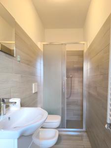 a bathroom with a toilet and a sink and a shower at Levico Antiche Terme Apartment in Levico Terme