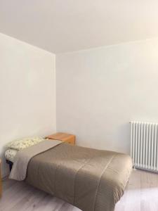 a bedroom with a bed in a white room at Levico Antiche Terme Apartment in Levico Terme