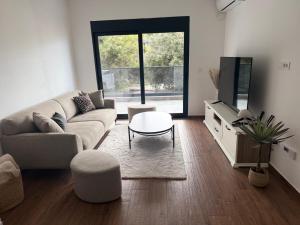 a living room with a couch and a tv at Brillex Swiss Residence in Dobra Voda