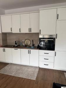 a kitchen with white cabinets and a stove top oven at Brillex Swiss Residence in Dobra Voda