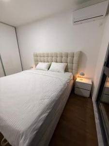 a bedroom with a large bed and a night stand at Brillex Swiss Residence in Dobra Voda