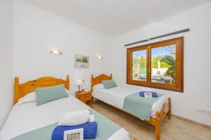 a bedroom with two beds and a window at Villa El Mal Pas / Can Seguinet in Alcudia