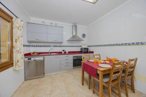 a kitchen with a table and a kitchen with white cabinets at Villa El Mal Pas / Can Seguinet in Alcudia