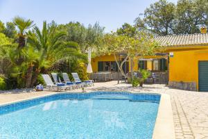 a swimming pool with chairs and a house at Villa El Mal Pas / Can Seguinet in Alcudia