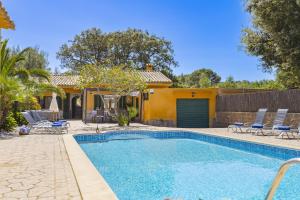 a swimming pool with chairs and a house at Villa El Mal Pas / Can Seguinet in Alcudia
