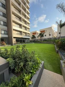 a lawn in front of a large apartment building at Nomah Homes The Bantree in Accra