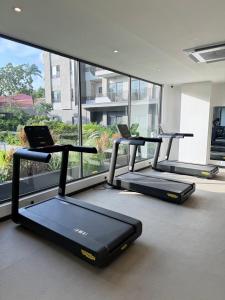 a gym with three treadmills in front of a window at Nomah Homes The Bantree in Accra