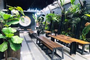 an outdoor patio with wooden benches and plants at Shade House - Phuket Downtown in Phuket