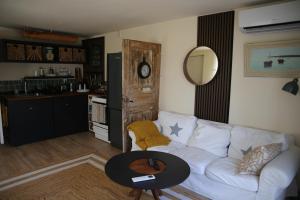 a living room with a white couch and a table at Schwedisches Waldcottage Fluss & Wanderwege in Fristad