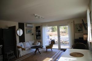 a living room with a couch and a table at Schwedisches Waldcottage Fluss & Wanderwege in Fristad