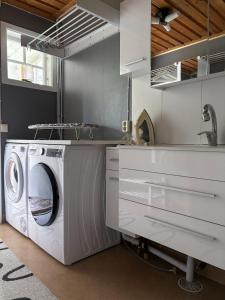 a kitchen with a washing machine and a sink at House on the hill in Södra Persby