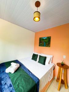 a bedroom with a bed with orange walls at Pousada Oxente Uai! in Pirenópolis
