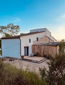 a white building with a fence next to it at Alojamiento Rural Montseny in Breda