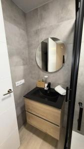 a bathroom with a sink and a mirror at Suite Muralla 2.3-B in Lugo