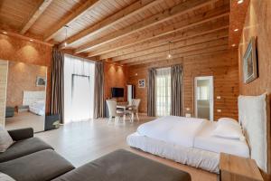 a bedroom with a large white bed and wooden walls at Bianca Hotel & Villa Tirana in Tirana