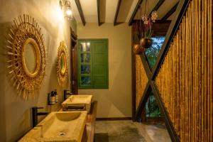 a bathroom with two sinks and a mirror on the wall at Tukki Ecolodge Hotel in Filandia