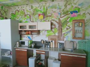 a kitchen with a tree mural on the wall at Ubytování v galerii in Zlatá Olešnice