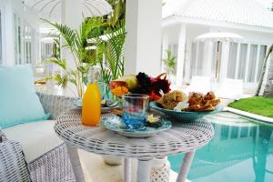 a wicker table with food on it next to a pool at Harmony Villas in Kuta Lombok