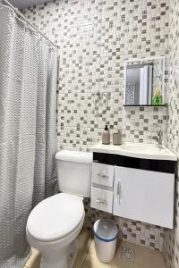 a bathroom with a white toilet and a sink at Casa no Vidigal da Nilda in Rio de Janeiro +13 photos